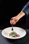 Cuttlefish ink Italian pasta, hand with fork, black color, trend, restaurant concept