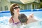 Cuty funny toddler boy and his teenage sister having fun in outdoor pool. Child learning to swim. Kid having fun with water toys.