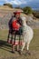 Cuzco, Peru - July 14, 2018. Peruvian woman in traditional colourful clothes with alpaca / llama at Sacsayhuaman, Cusco, Peru