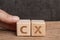 CX, Customer Experience concept, hand holding cube wooden block arrange the word with alphabet CX with dark background, important