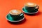 Cyan coffee cups over orange background.