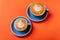 Cyan coffee cups over orange background.