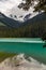 Cyan-turquoise waters of Lower Joffre Lake reflect forested mountains