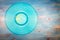 Cyan vinyl record on blue wooden background