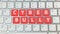 Cyber bullying red button on silver keyboard