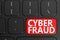 Cyber Fraud on black keyboard