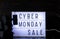 Cyber Monday Sale words on lightbox with black price tag and gifts front view
