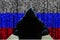 Cyber threat from Russia. Russian hacker at the computer, on a background of binary code, the colors of the flag of Russia. DDoS