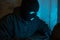 Cybercrime, hacking and technology crime. Masked hacker working in the darkness stealing data and personal identity information