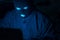 Cybercrime, hacking and technology crime. Masked hacker working in the darkness stealing data and personal identity information