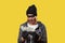 Cybercrime and money theft. A woman in a hat, gloves and mask holds a wad of money. Yellow background. Copy space