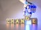 Cyborg robot hand changes text cube from change to chance - ai concept