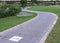 cycleway signposted a ground bikeway with two cyclists circling at background. Bike lane between trees Jardin Turia in