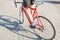 Cycling athlete`s foot and red bike close-up. Man rides the city on a bicycle. Sports concept