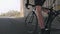 Cycling concept. Strong leg muscles pedaling bicycle. Cyclist riding bike out of the saddle. Close up follow shot. Slow motion