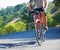 Cycling, fitness and legs of man on a bicycle in road for training, wellness or sport outdoor. Health, exercise or male