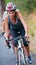 Cycling, fitness and portrait of woman on a bicycle in road for training, wellness or sports race. Health, exercise or