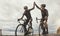 Cycling, friends and high five by men training, cycling and exercising in road with motivation, goal and energy. Fitness