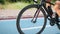 Cycling gear, bike wheel rotation, chain and cassette, close up. Cyclist`s legs pushing pedals on bicycle on cycle path. Sport rec