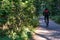 Cycling through the park. A man in a jacket rides a bicycle along the path.