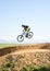 Cycling, sports and man in air on bicycle for adrenaline on adventure, freedom and jump for speed. Mountain bike, tricks