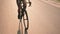 Cycling at sunrise. Triathlon. Athlete cyclist twists pedals, rotate wheel on road bike in sun light. Cycling triathlon intensive