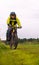 Cycling tourist on a dirt road through a field