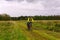 Cycling tourist rides on a dirt road through a field