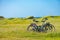 Cycling and wildcamping - two bicycles in the green machair field, with a tent in the background