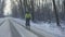 Cycling in winter. The cyclist rides on a slippery asphalt road. Man in a helmet and warm sportswear rides in a winter