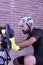 Cyclist adjusting his bike next to a brick wall