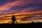 A cyclist against a beautiful sunset. A man stands with a bicycle and looks at the sunset