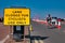 A cyclist approaches a yellow sign advising that a road lane is closed to cars