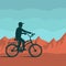 Cyclist on a background of red mountains