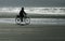 Cyclist on beach at dawn