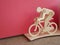 cyclist on a bicycle made of wood on a pink background