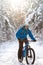 Cyclist in Blue Riding the Mountain Bike in Beautiful Sunny Winter Forest. Extreme Sport and Enduro Biking Concept.