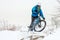 Cyclist in Blue Riding Mountain Bike on Rocky Winter Hill Covered with Snow. Extreme Sport and Enduro Biking Concept.