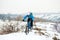 Cyclist in Blue Riding Mountain Bike on Rocky Winter Hill Covered with Snow. Extreme Sport and Enduro Biking Concept.