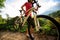 Cyclist carrying mountain bike climbing on summer forest trail