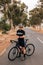 Cyclist checking smartwatch while taking a break on empty country road