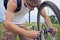 Cyclist checks brake wheel of bicycle