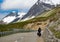 A cyclist climbing Albula pass street, Switzerland, towards high alpine terrain