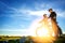 Cyclist couple with mountain bikes standing on the hill under the evening sky and enjoying bright sun at the sunset.