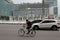 A cyclist crosses the HI Roundabout Bundaran HI with Welcome Monument Tugu Selamat Datang in the middle