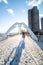 Cyclist crossing an icy snow covered pedestrian arch bridge.