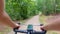 Cyclist drives in forest on curvy gravel road.