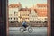Cyclist driving past Nyhavn riverbank with historical houses and restaurants of city leisure area