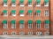 Cyclist driving past old brick house with many windowds in historical area of Copenhagen, Denmark. One of city bicyclist