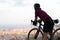 Cyclist grasping the handlebars of a road bike observing the city of Barcelona